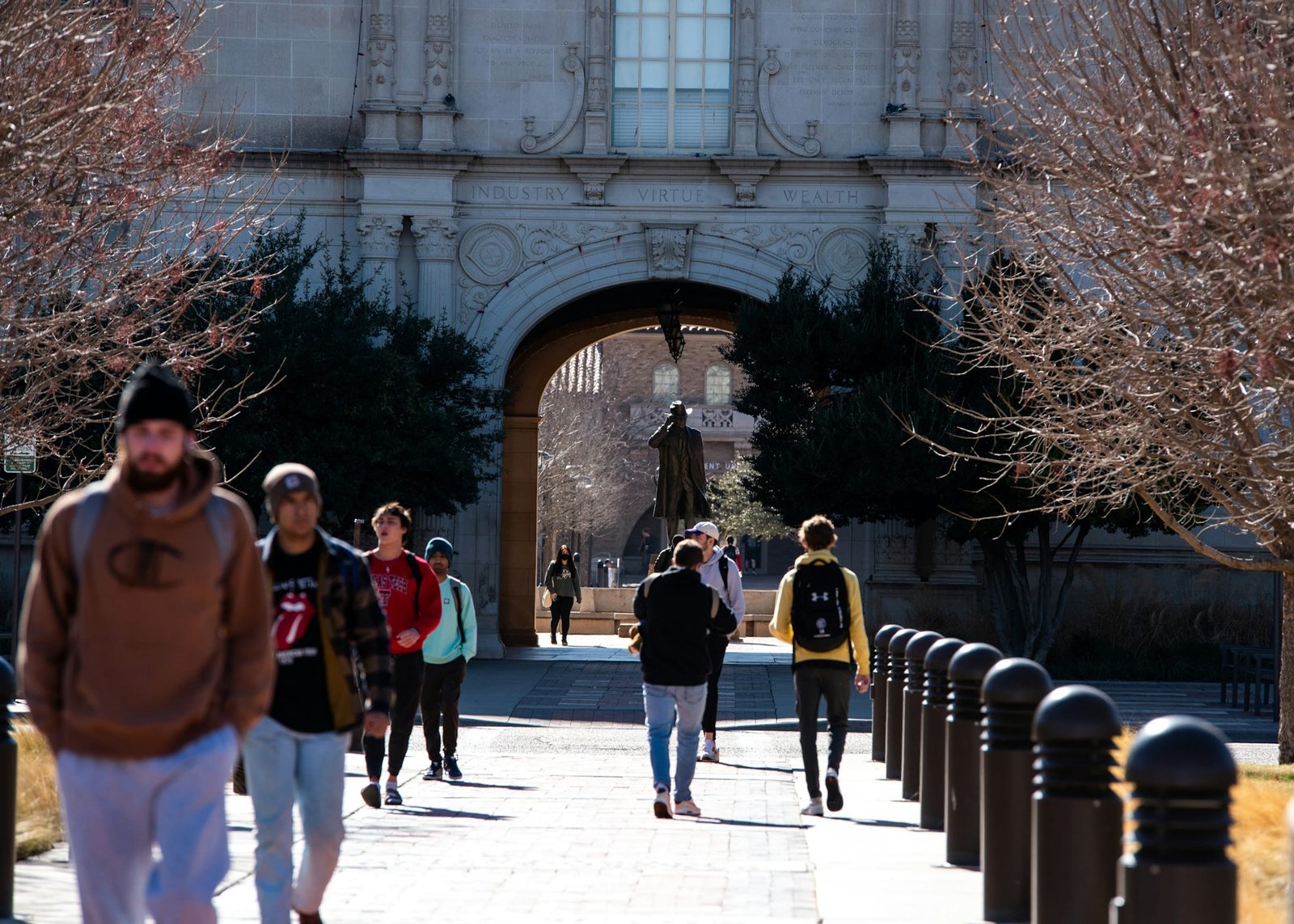 Students walking through a university campus archway